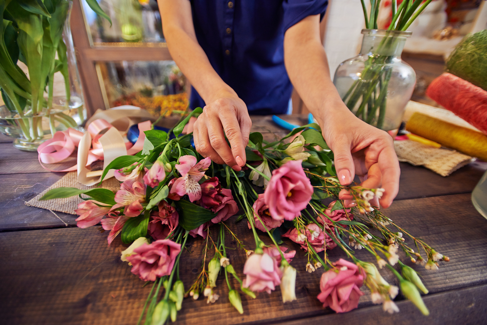 Female,florist,working,with,flowers,in,workshop