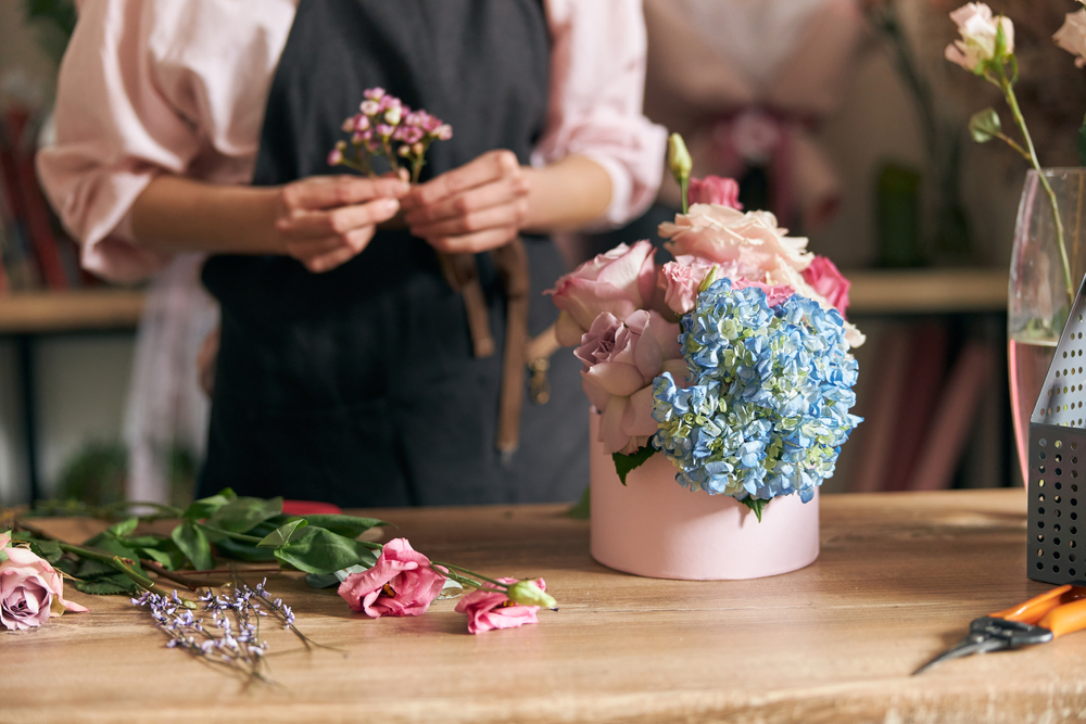 Professional,florist,young,woman,is,doing,bouquets,at,flower,shop