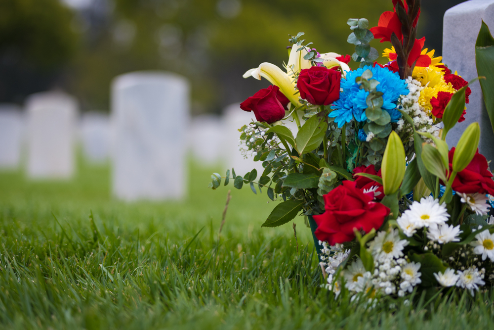 White,grave,markers,and,flowers,at,a,national,cemetary